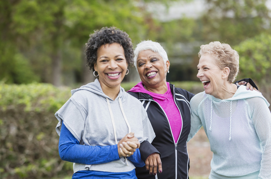 Three friends laughing after a workout