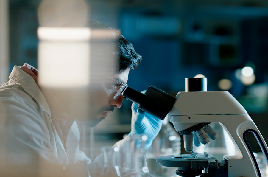 Scientist looking through a microscope